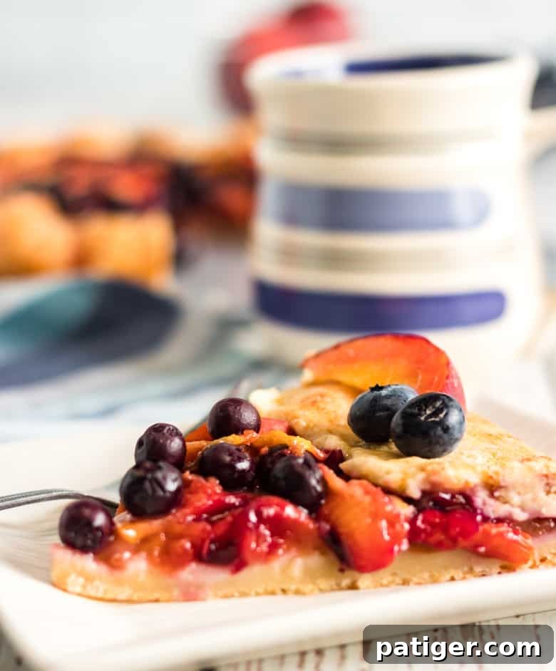 Close-up of a golden brown peach blueberry galette with caramelized fruit filling, showcasing the rustic folded crust.