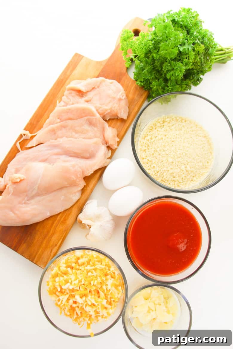 Ingredients for Easy Baked Chicken Parmesan, showing fresh chicken, cheese, sauce, and breading components