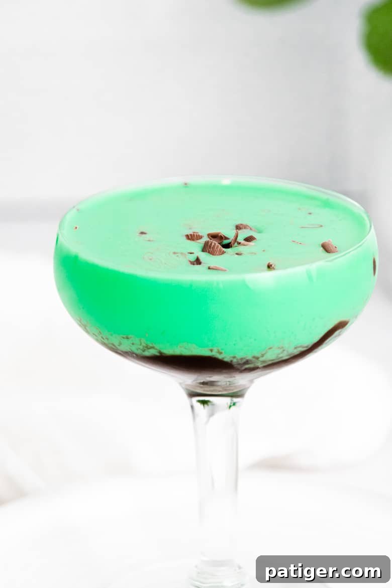 Emerald Elixir 2 Green Grasshopper cocktail topped with chocolate shavings in a classic coupe glass