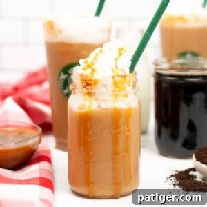 Caramel Frappuccino topped with whipped cream and caramel drizzle served in a mason jar with green straw