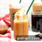 Caramel Frappuccino topped with whipped cream and caramel drizzle served in a mason jar with green straw