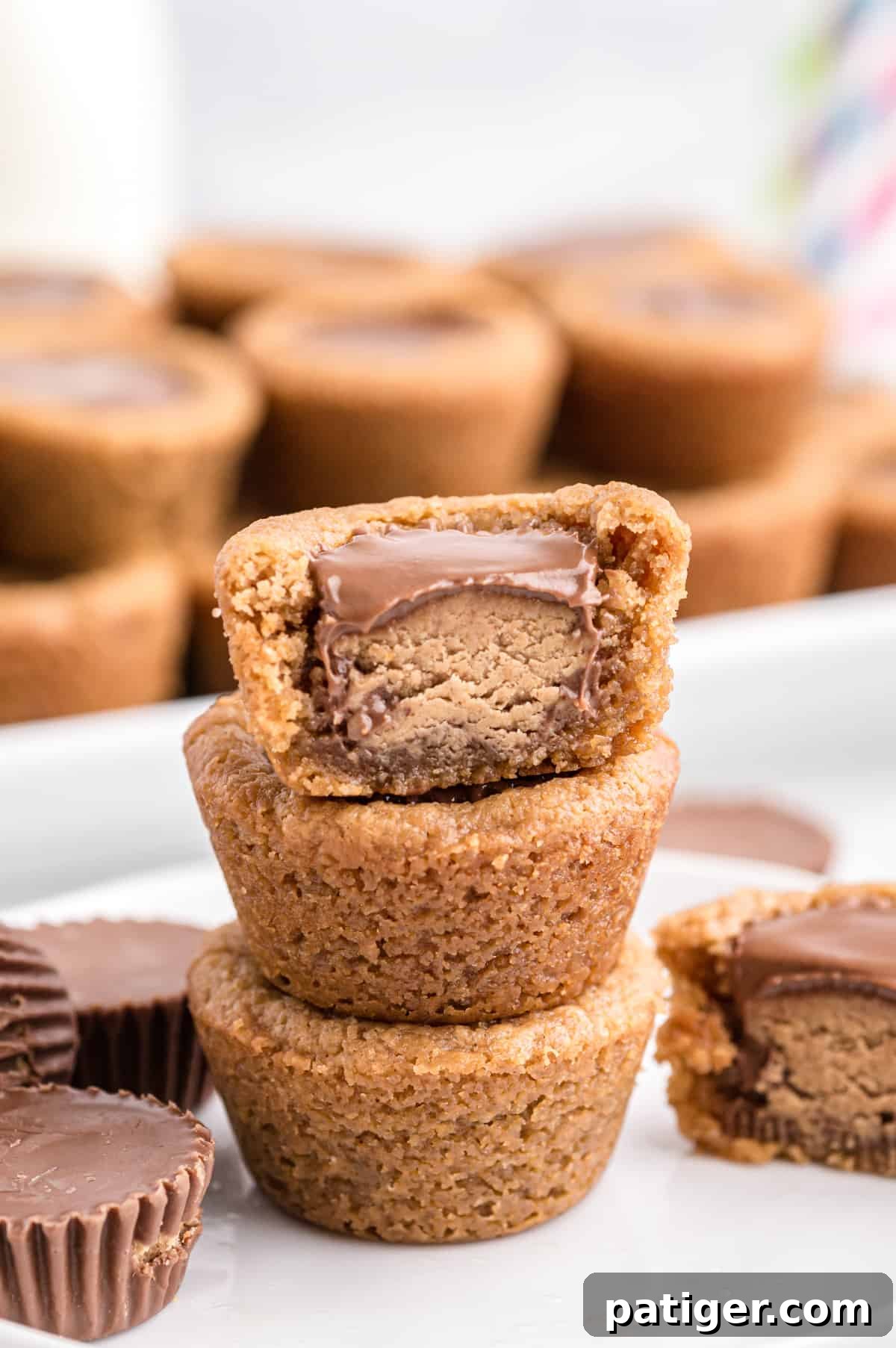  three peanut butter cup cookies stacked, top cookie cup has bite taken out of it
