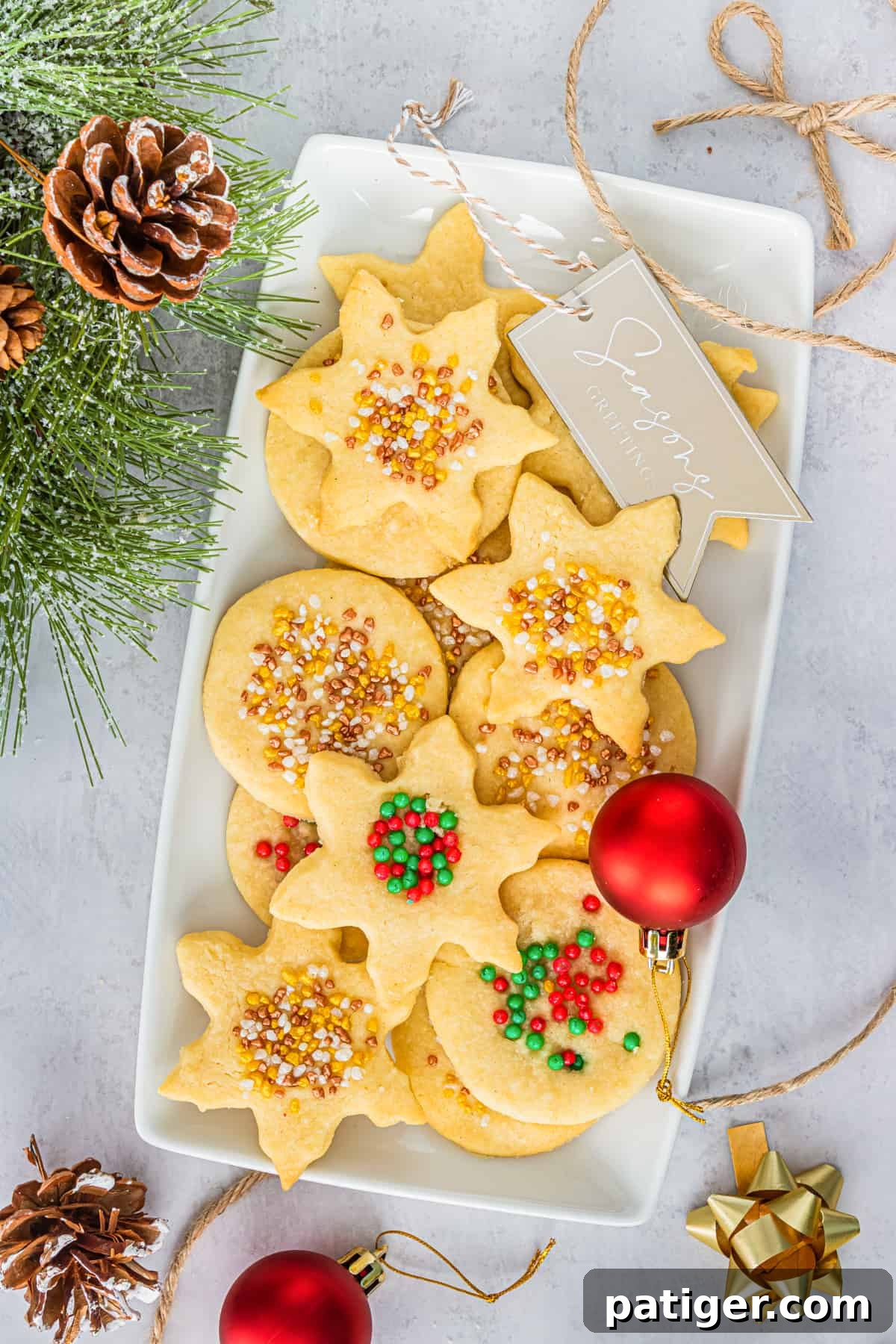 Christmas Shortbread Cookies with sprinkles on serving platter with christmas decor around them