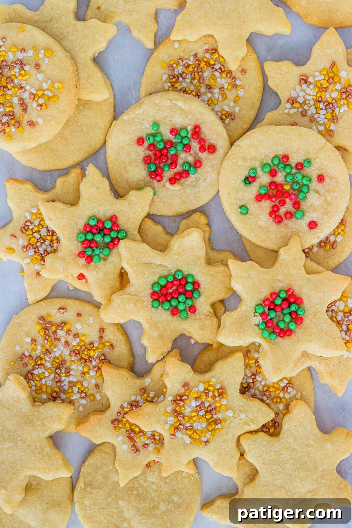 Holiday Shortbread Cookies topped with Sprinkles piled on countertop