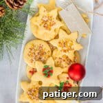 Christmas Shortbread Cookies cut in snowflake and circle shapes, and decorated with holiday sprinkles.