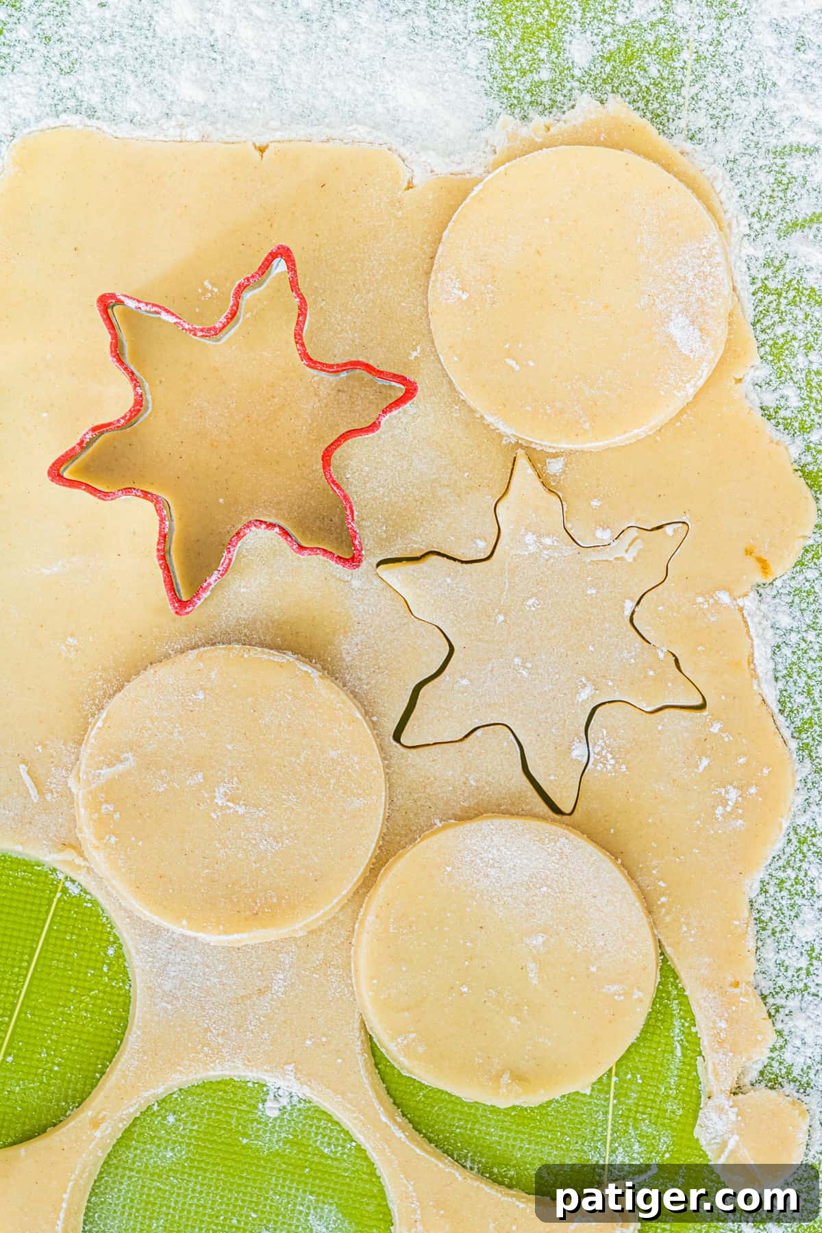 Shortbread cookies being cut with snowflake and circle cookie cutters