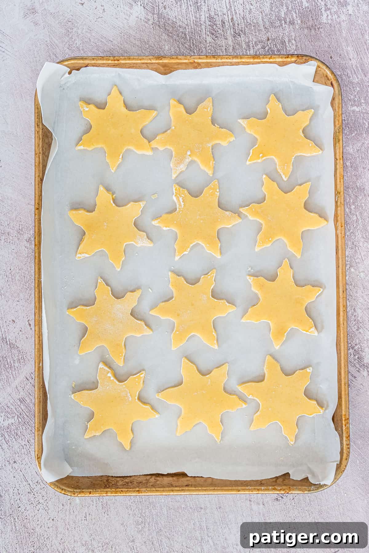 unbaked shortbread cookies on lined baking sheet, arranged evenly and close together