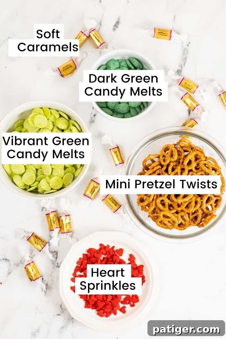 Ingredients in bowls: vibrant green candy melts, dark green candy bites, ini pretzel twists, red hart sprinkles, and soft caramels