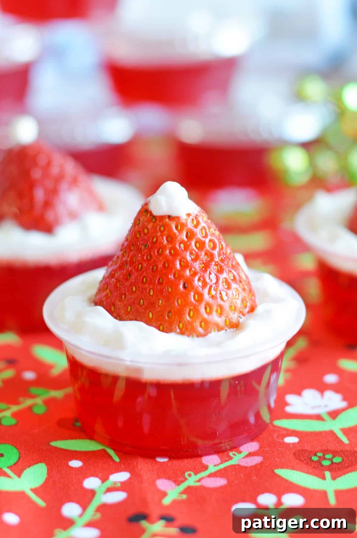 Close-up shot of a single Strawberry Santa Hat Jello Shot, showcasing its detailed decoration and inviting appearance.