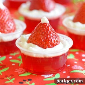Strawberry Santa Hat Jello Shots made with strawberry jello, whipped cream, and fresh strawberries