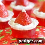 Strawberry Santa Hat Jello Shots made with strawberry jello, whipped cream, and fresh strawberries