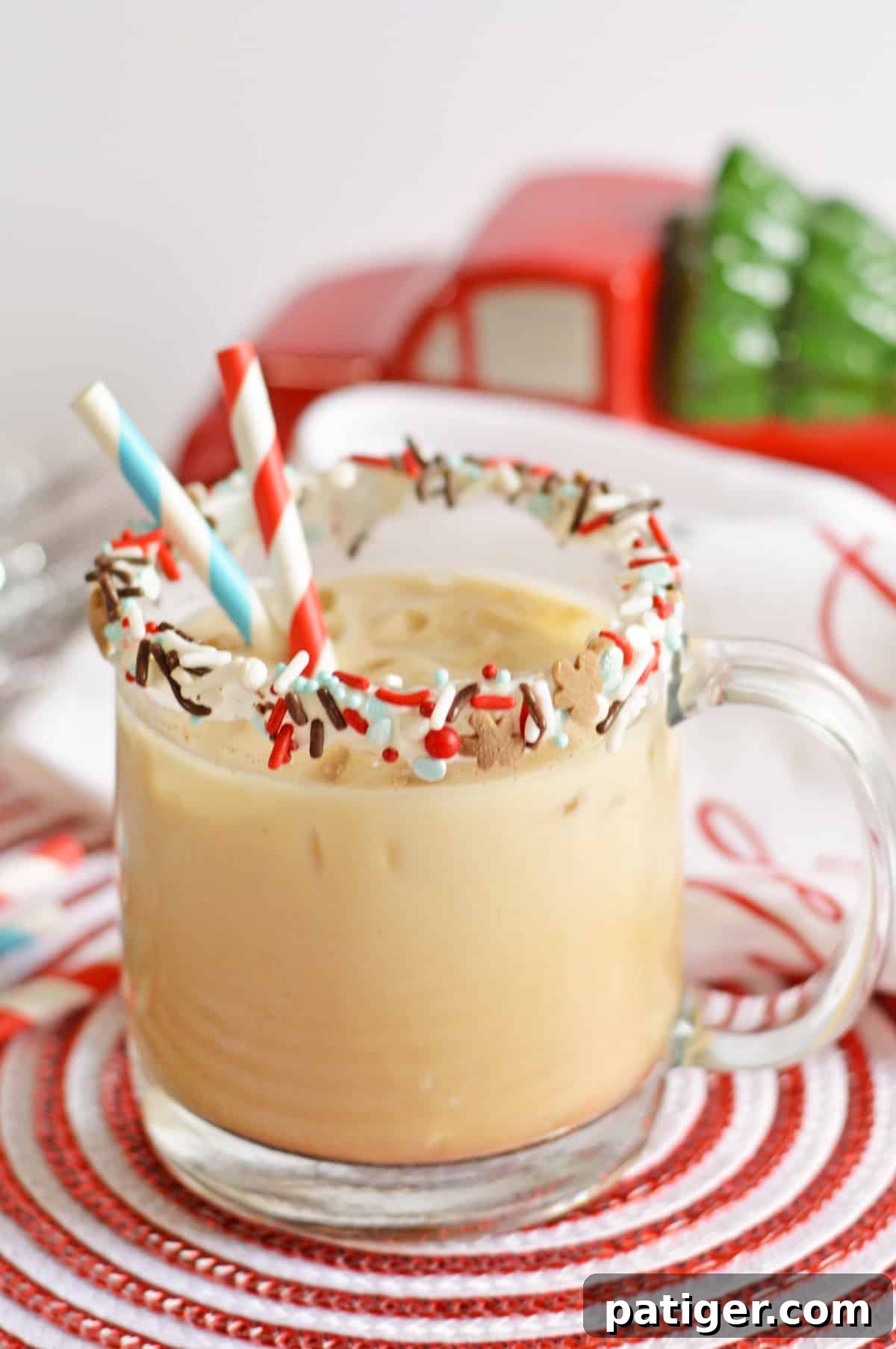 Gingerbread Cookie Cocktail in a glass mug rimmed with vanilla frosting and festive sprinkles, set against a cozy holiday backdrop.