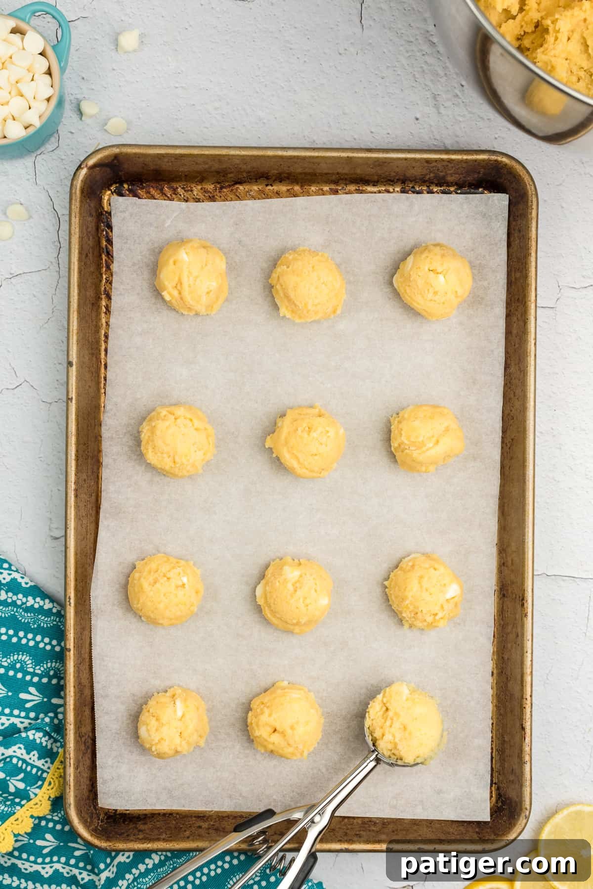 Lemon cookie dough scooped onto a parchment-lined baking sheet.