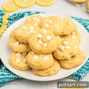 Lemon pudding cookies with white chocolate chips on a plate.