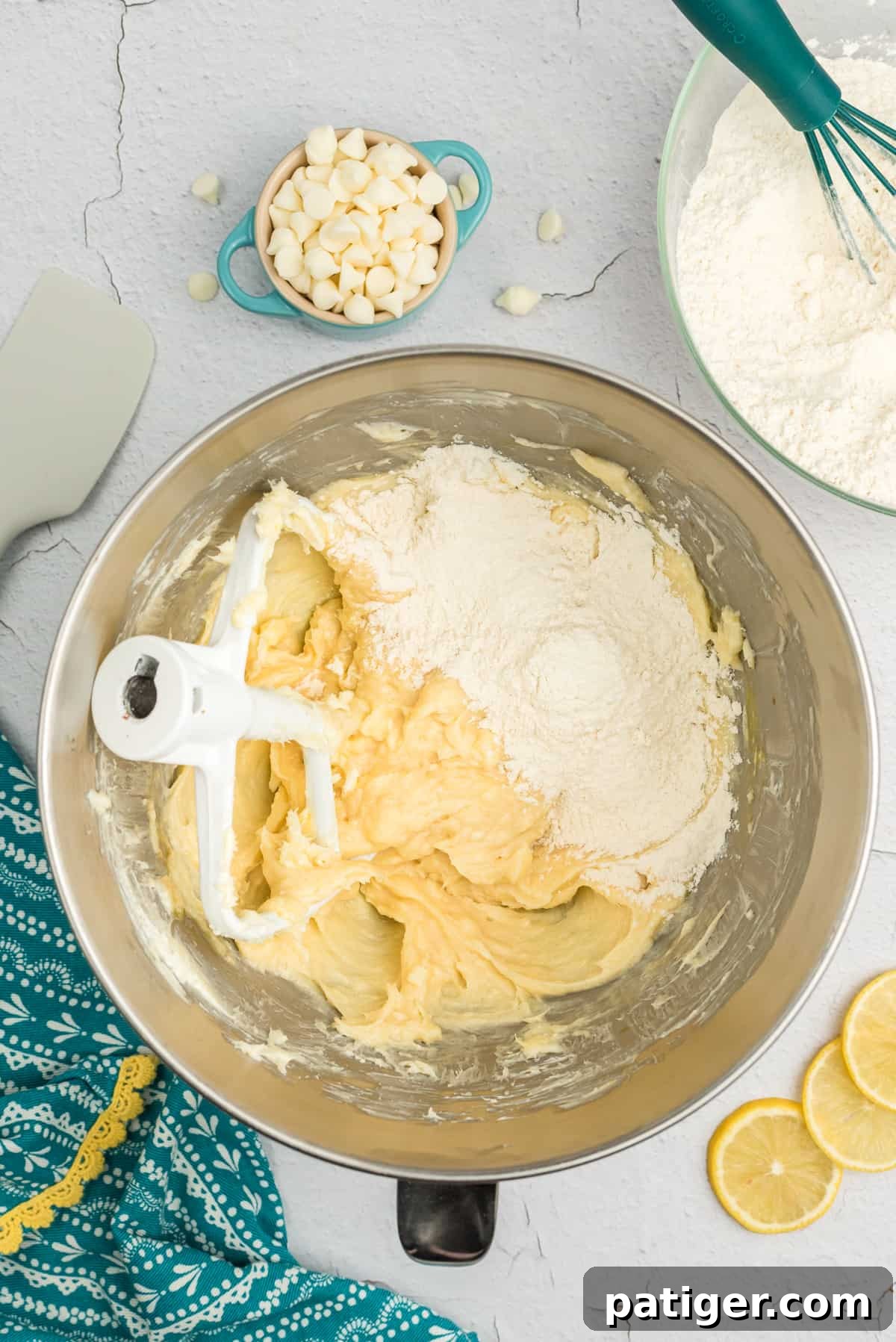 Dry ingredients being added to wet ingredients in the bowl of a stand mixer.
