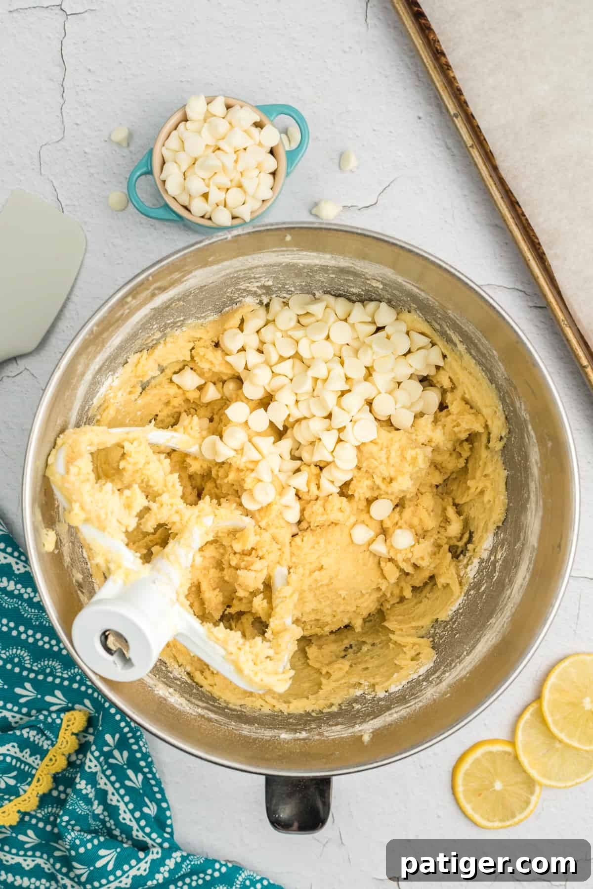 White chocolate chips being folded into lemon cookie dough.