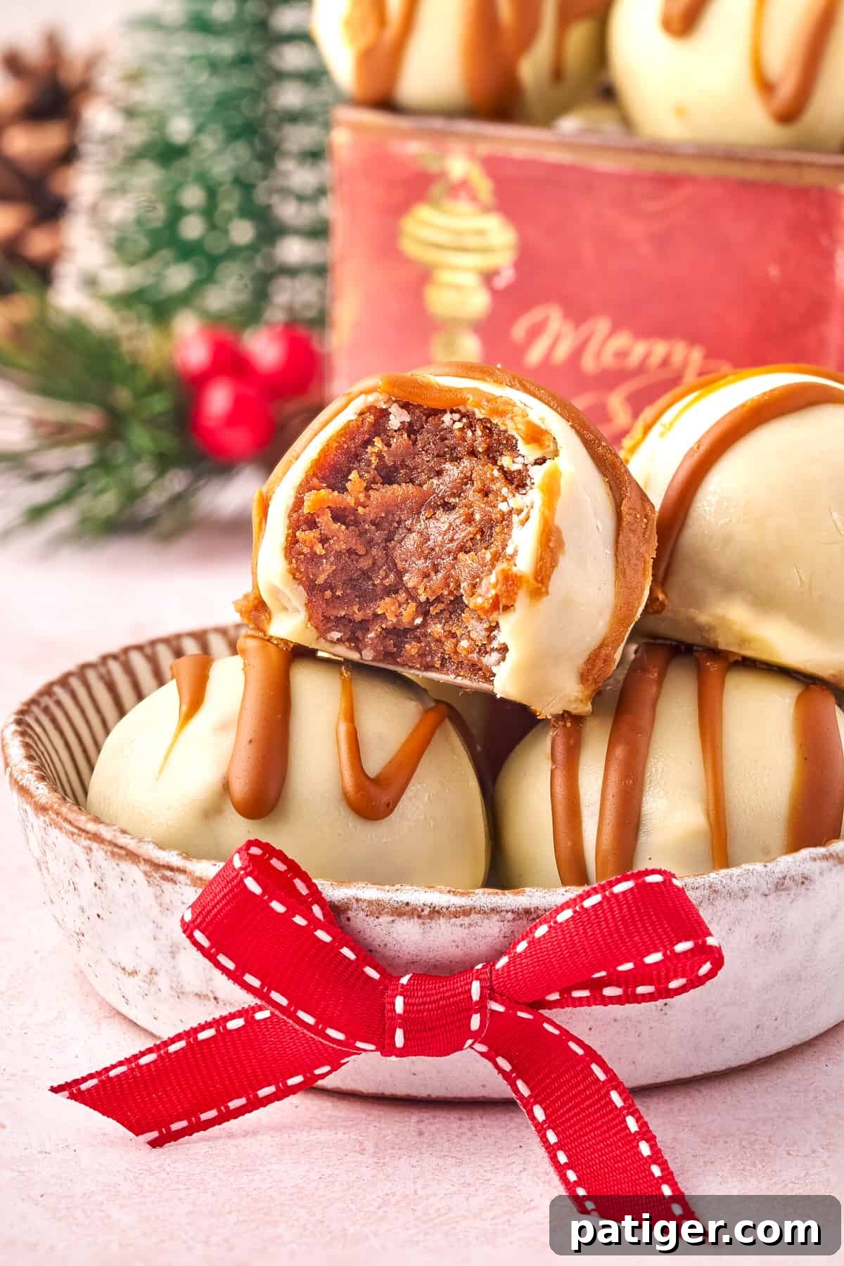 Close-up of a no-bake cookie truffle with a bite taken out, revealing its creamy, spiced interior and white chocolate coating.