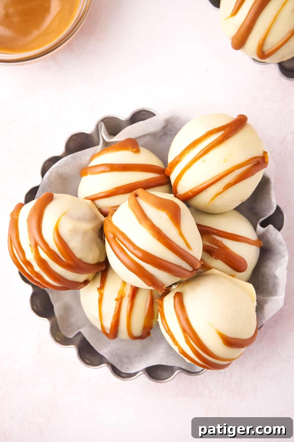 Serving dish filled with No-Bake Biscoff Truffles, beautifully topped with a delicate drizzle of Biscoff cookie butter.