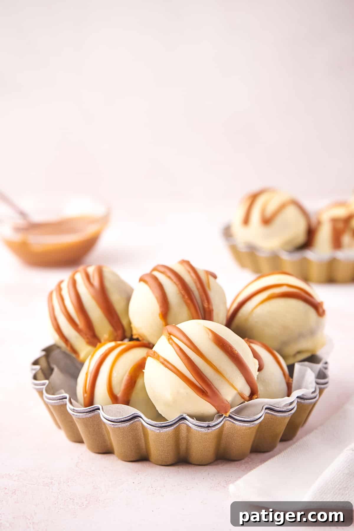 A selection of no-bake Biscoff cookie truffles, featuring a glossy white chocolate coating and a delicate drizzle of Biscoff cookie butter.