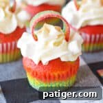 Rainbow Cupcakes with whipped cream cream cheese frosting and decorated with rainbow candy on top.