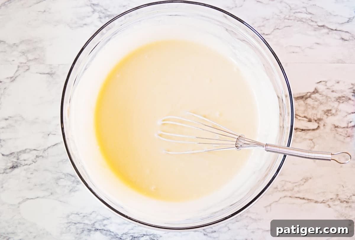 Cupcake batter in mixing bowl with whisk.