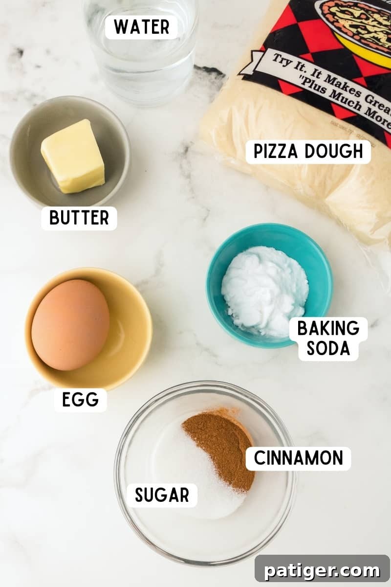 Array of ingredients for cinnamon sugar pretzel bites laid out on a white surface, including dough, butter, sugar, and cinnamon.