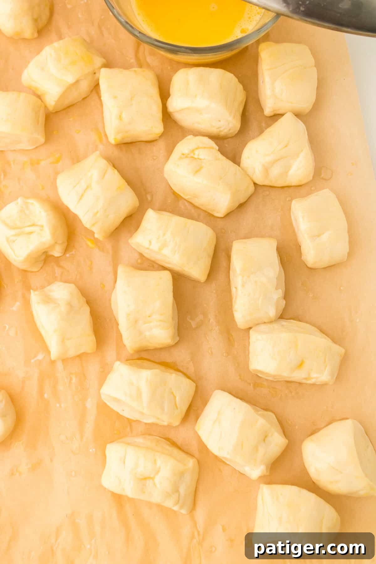 Pretzel dough pieces neatly arranged and brushed with egg wash, ready for air frying.