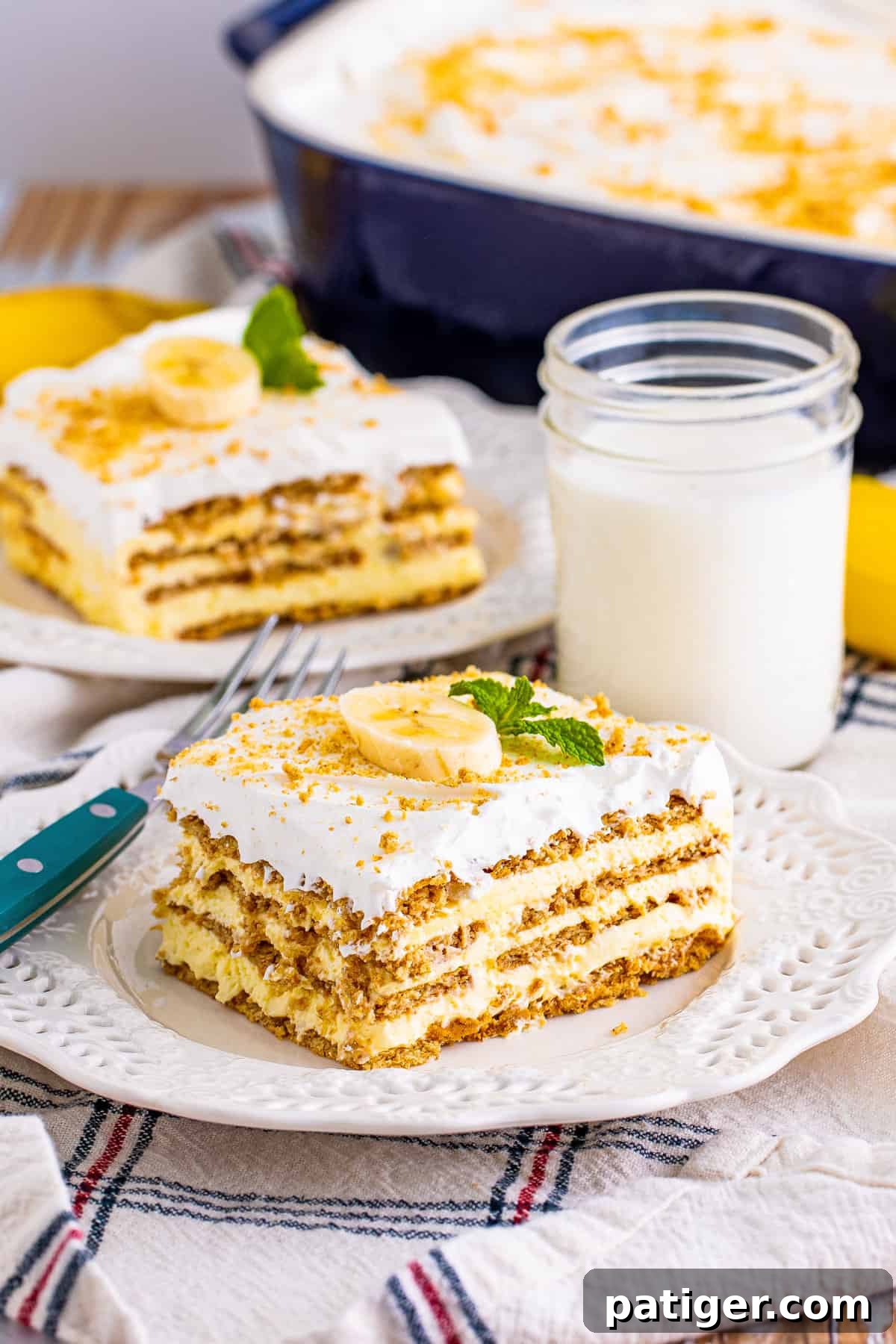 Square slice of no bak banana pudding cake topped with crushed graham crackers and slice of banana.
