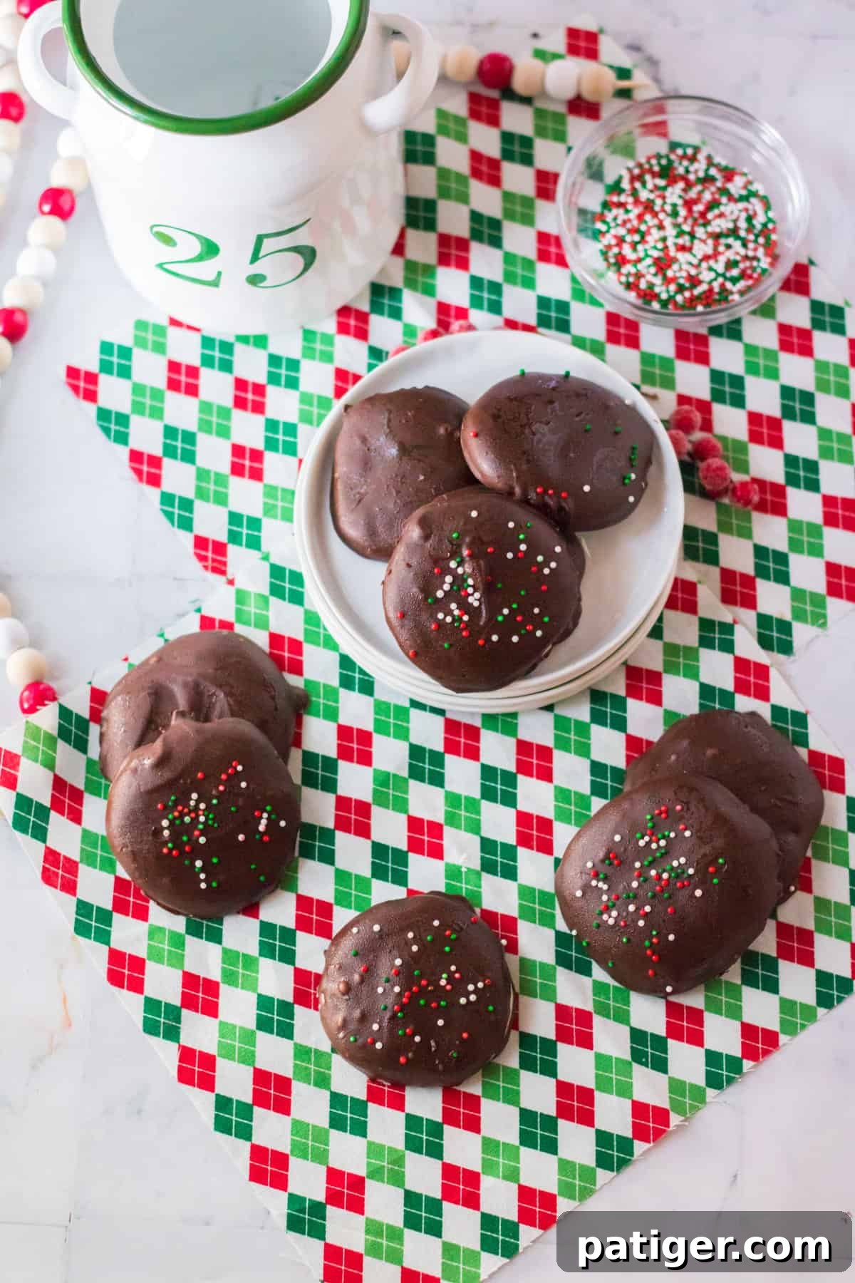 A festive arrangement of copycat York peppermint patties, adorned with vibrant Christmas sprinkles, resting on a white plate surrounded by a holiday-themed napkin.