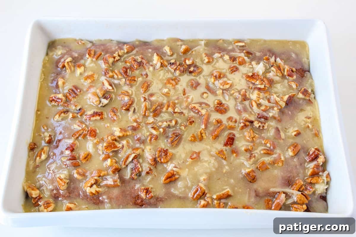 Coconut pecan frosting spread on top of the cake.