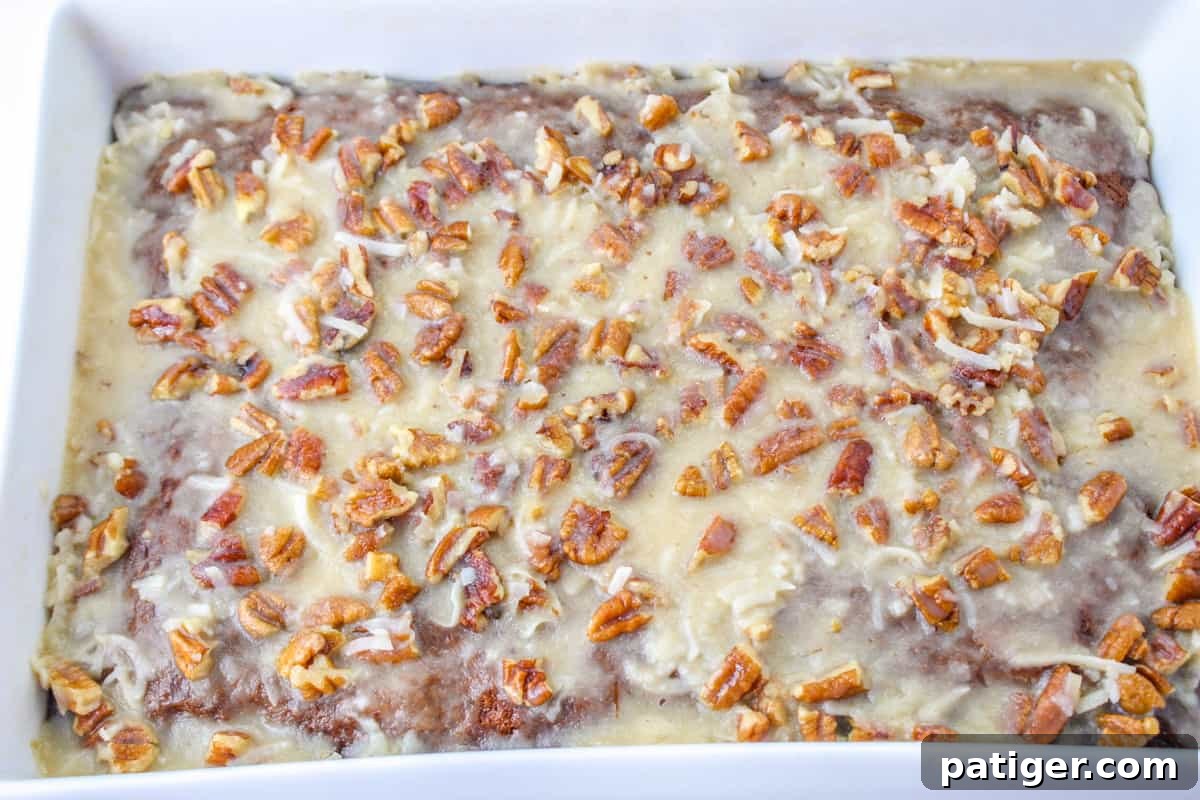 Fruit cocktail cake with coconut pecan frosting in rectangular baking dish.
