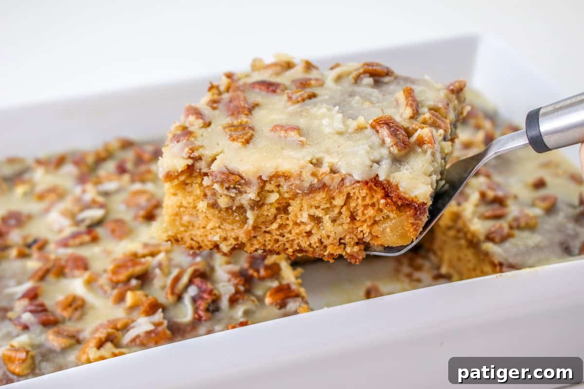 Spatula lifting a square slice of fruit cake out of the pan.