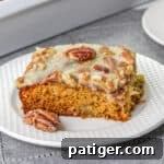 Slice of fruit cocktail cake topped with pecan coconut frosting.