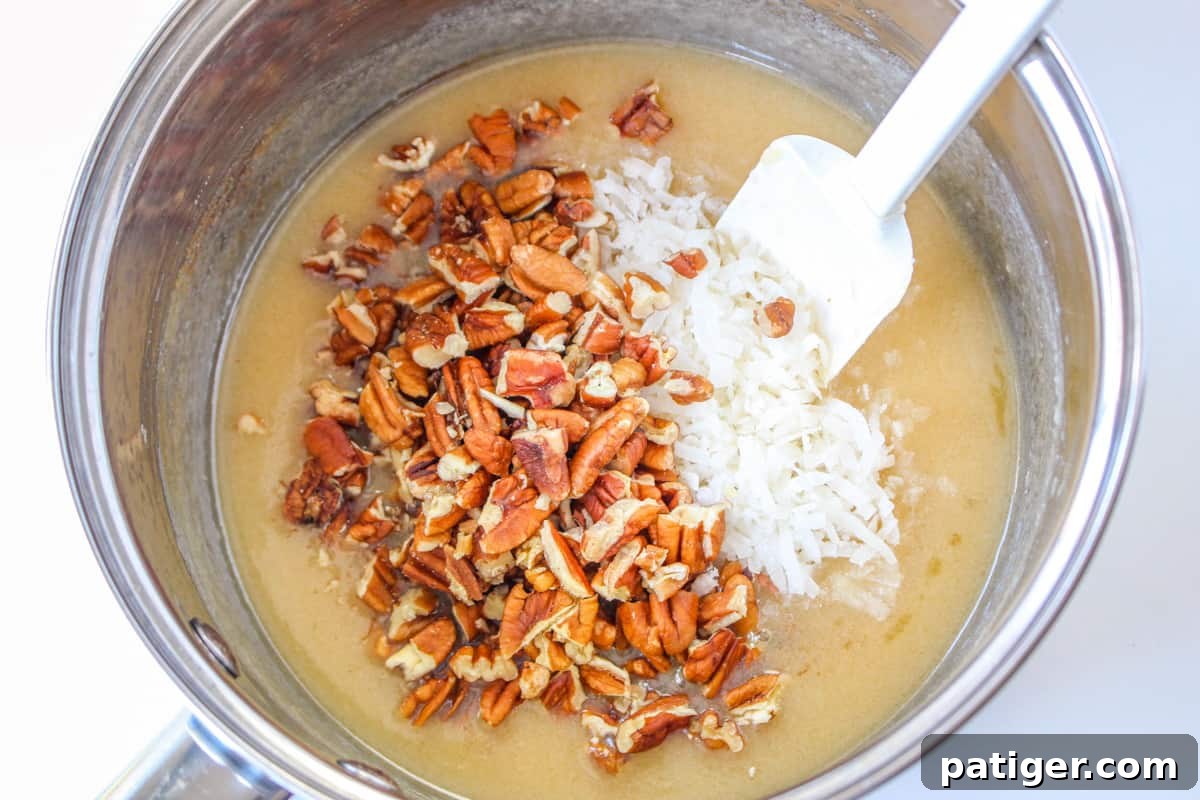 Frosting mixture in sauce pan with shredded coconut and pecans added.