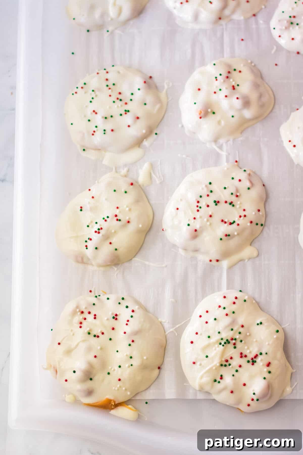 A freshly dipped polar bear paw candy, still wet with white chocolate, placed on parchment paper to set.