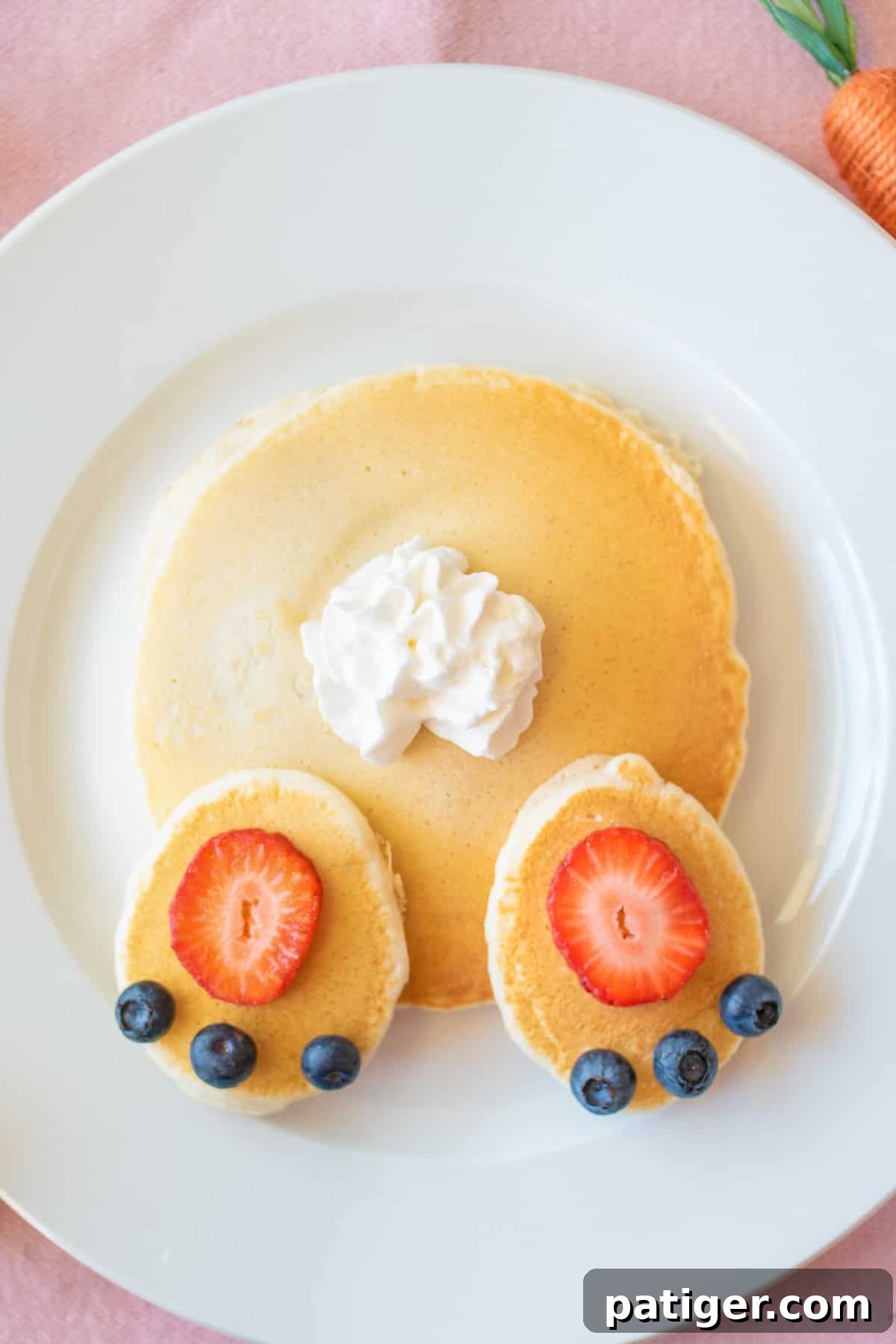 Cottontail Pancakes 3 Easter pancakes topped with strawberry slices, blueberries, and whipped cream arranged to look like a bunny's butt.