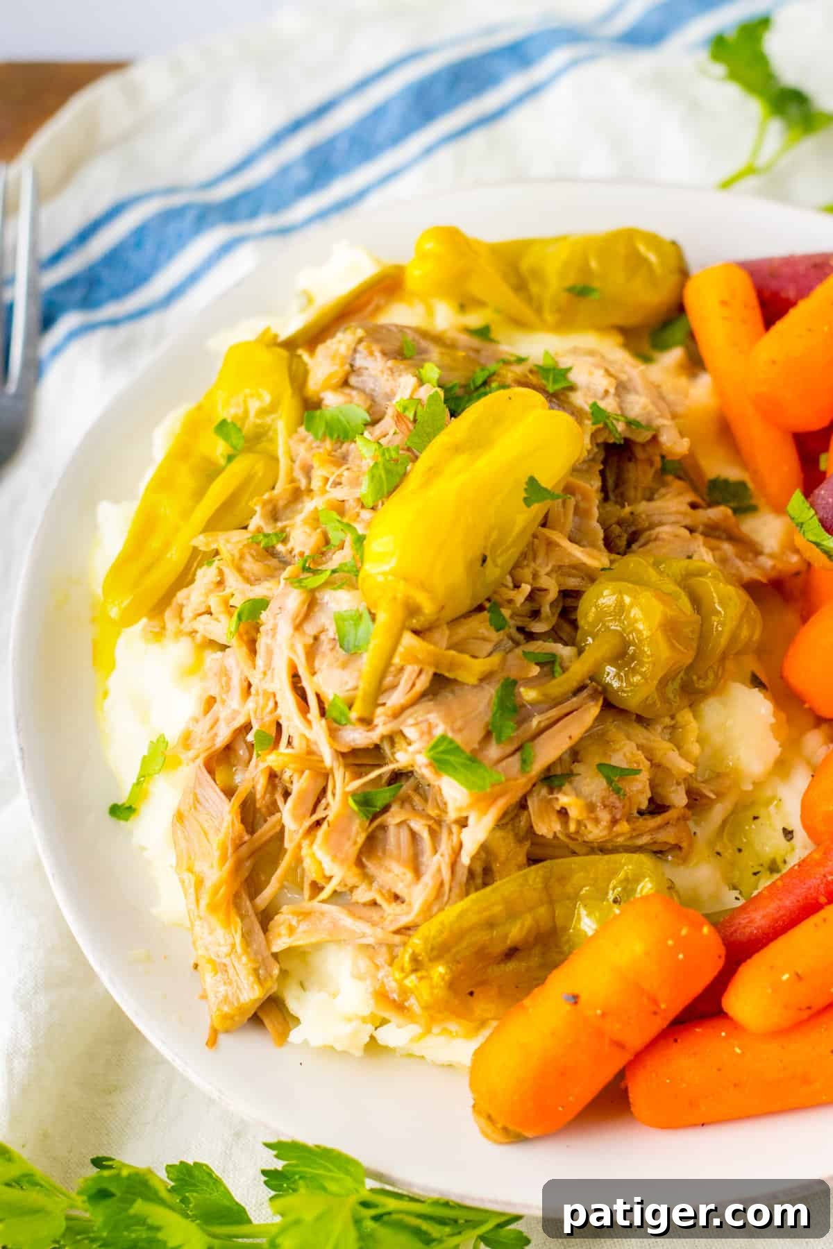 Juicy slow cooker Mississippi pork roast with pepperoncinis and carrots, ready to be served.