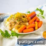 Slow cooker mississipi pork served over mashed potatoes with a side of carrots.