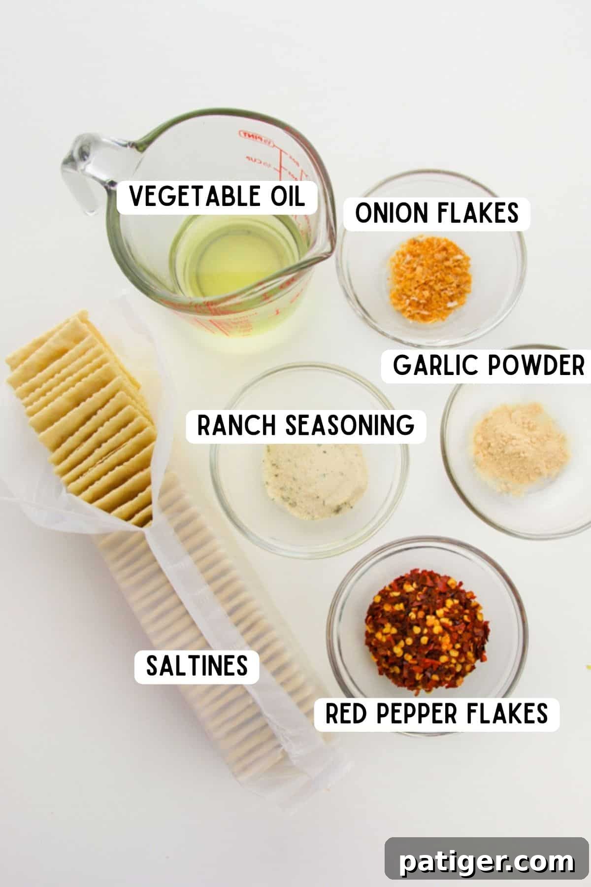 A display of key ingredients for Alabama Fire Crackers: vegetable oil, onion flakes, ranch seasoning, garlic powder, red pepper flakes, and saltines.
