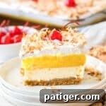 Pina colada lush dessert sliced into a square and served on a white plate.