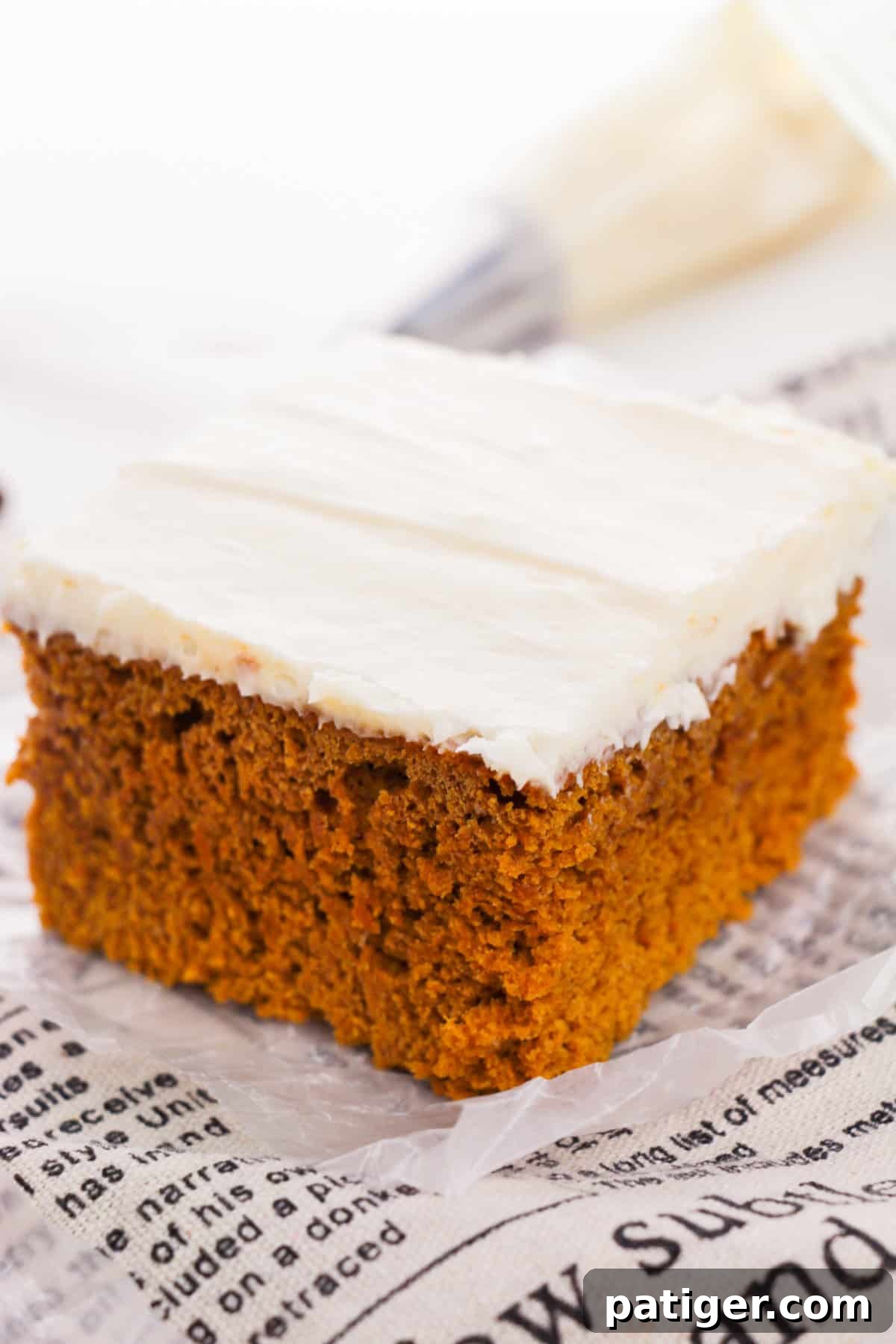 Moist two-ingredient pumpkin spice cake topped with a dollop of cream cheese frosting and a sprinkle of cinnamon.
