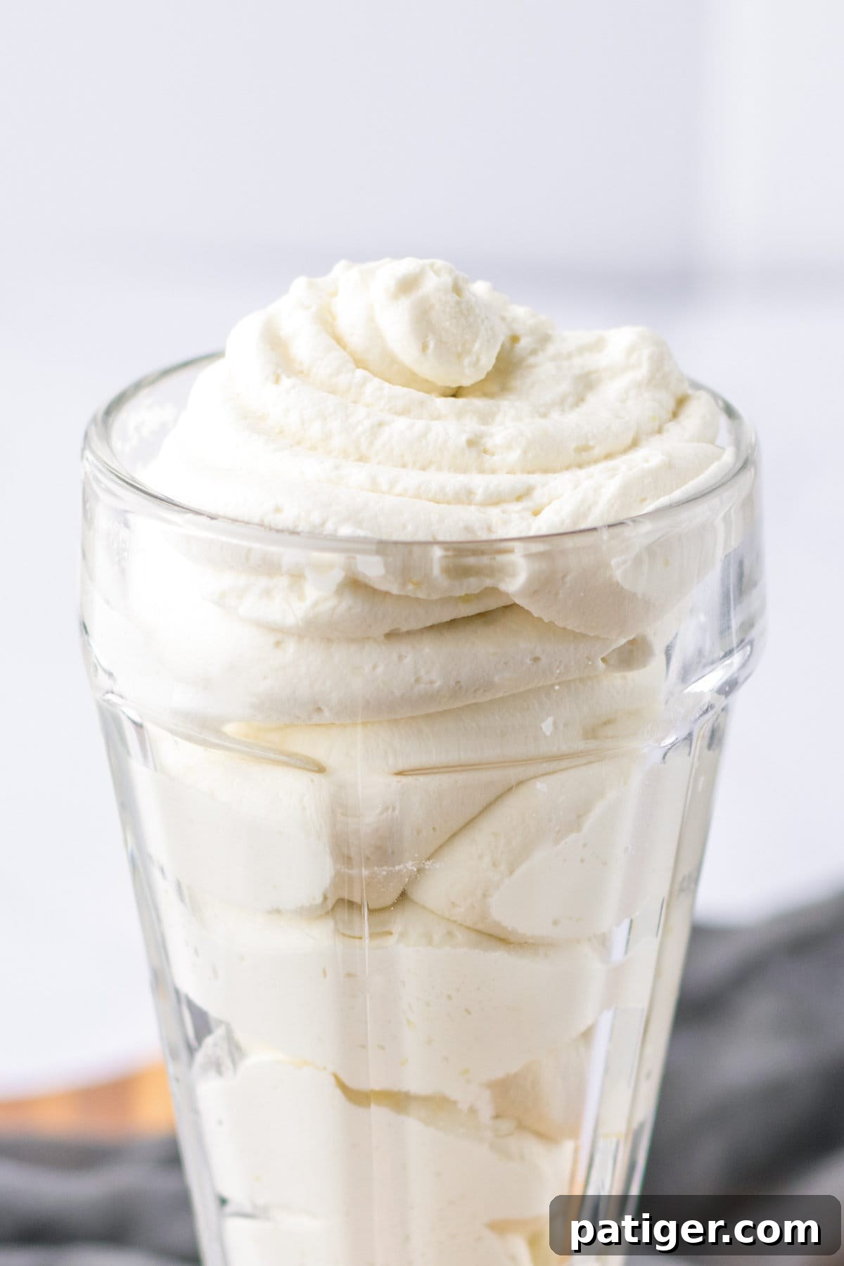 Homemade cool whip substitute in a glass, showcasing its creamy texture.