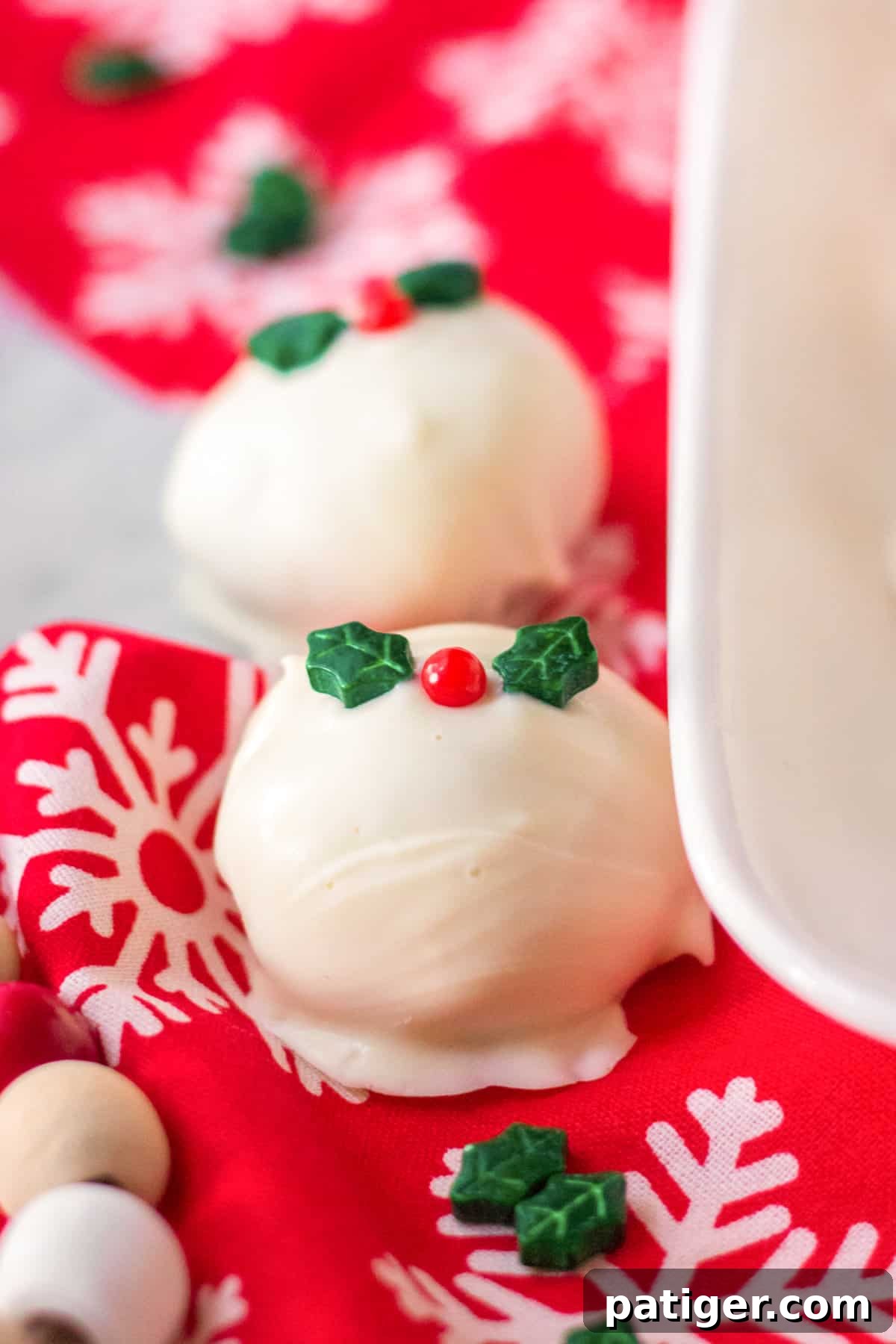 Truffles coated in almond bark and topped with Wilton Christmas mistletoe candy decoration.