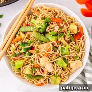 Ramen Stir-fry with vegetables in a white bowl with chopsticks.