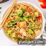 Ramen Stir-fry with vegetables in a white bowl with chopsticks.