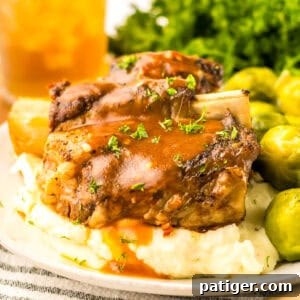 Slow Cooker Short Ribs served over mashed potatoes and topped with brown gravy.