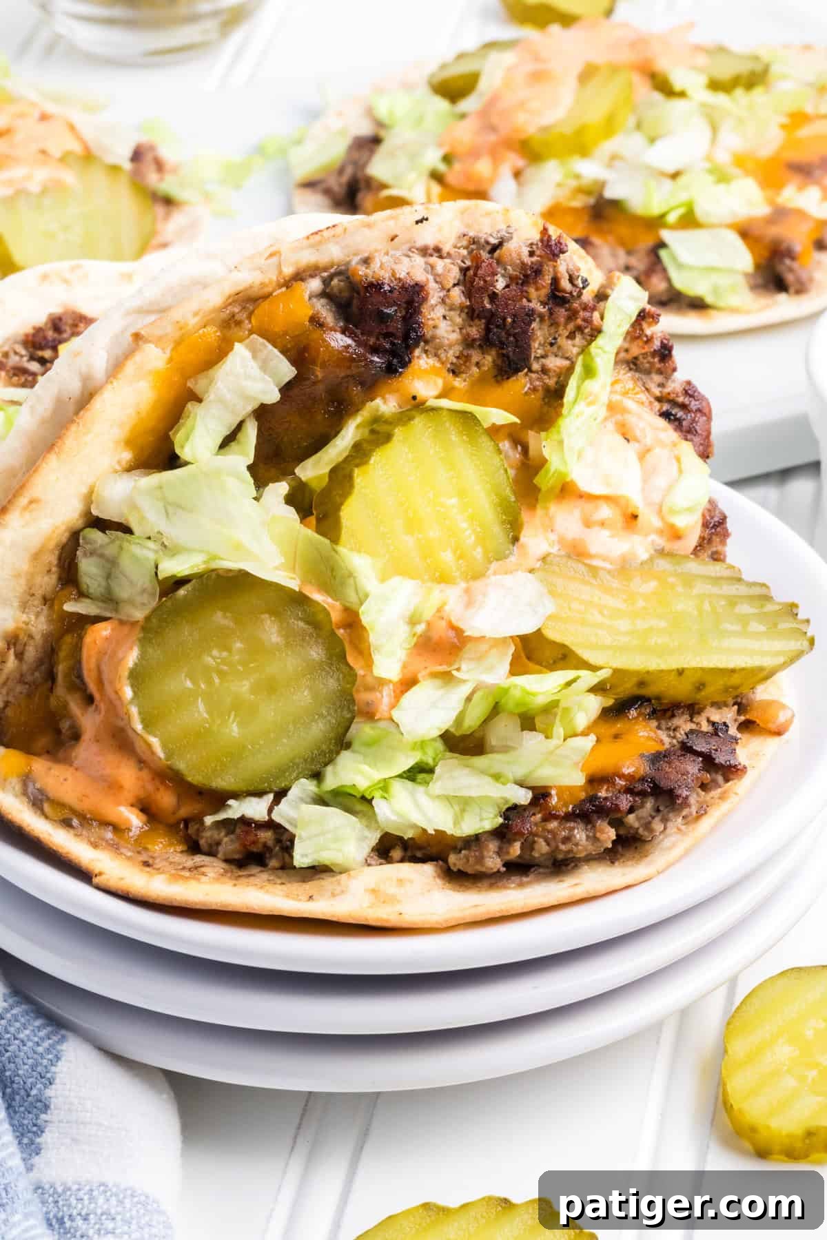 Delicious Big Mac Smash Tacos arranged on flour tortillas, showcasing seasoned ground beef, fresh lettuce, sliced pickles, and a generous drizzle of special sauce.