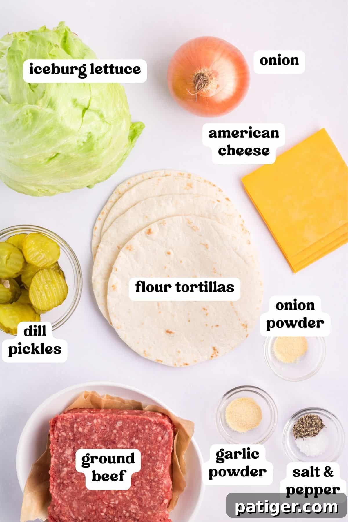 Individual ingredients for smash burger big mac tacos: fresh iceberg lettuce, finely minced onion, slices of American cheese, lean ground beef, small flour tortillas, sliced dill pickles, and a selection of seasonings.