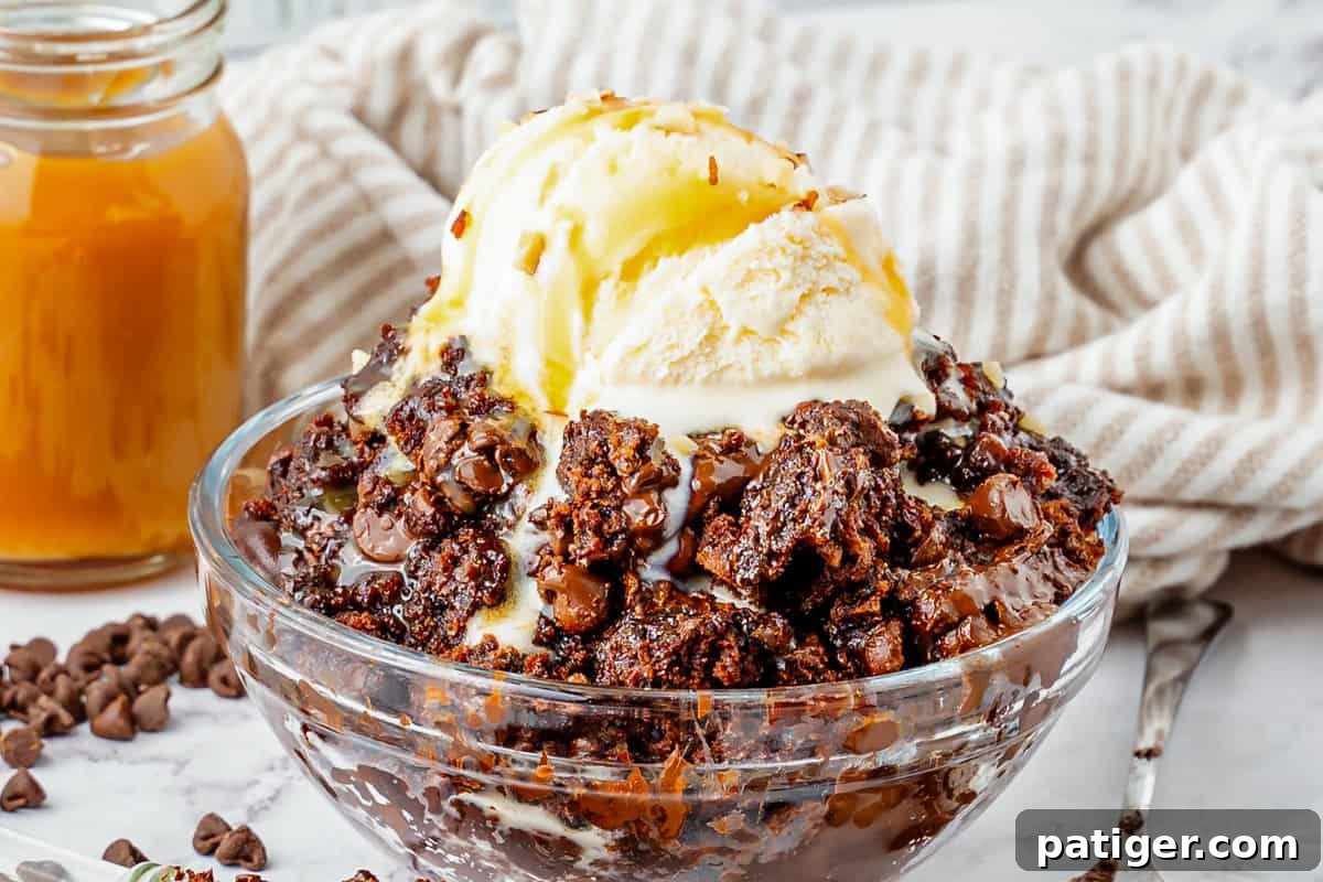 A delectable chocolate dump cake topped with a generous scoop of vanilla ice cream and a flowing caramel sauce drizzle.