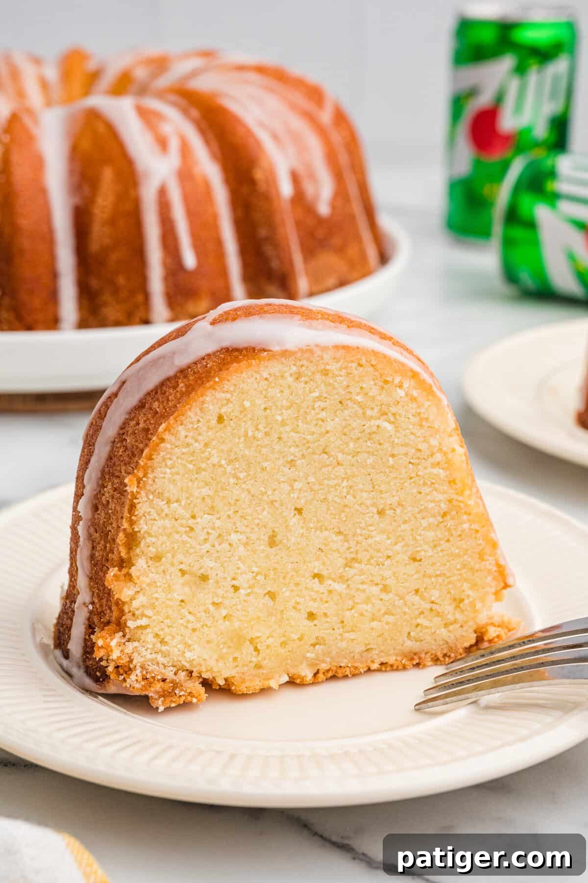 Slice of 7 Up pound cake on a white plate, showing the moist interior.